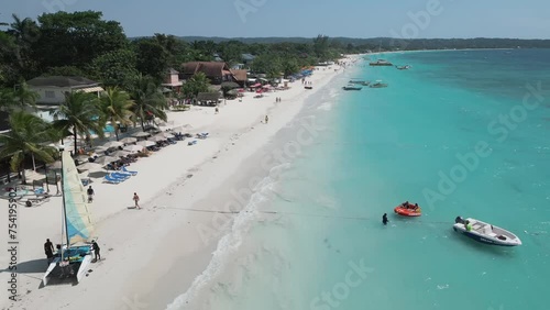 Aerial video above vacationing people and boats on jamaica coastline