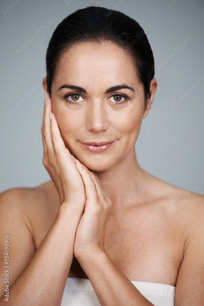 Woman, studio and portrait with hands, skin and care for treatment and proud. Model, cosmetics and natural with lip gloss, glow and aesthetic for antiaging confidence isolated on grey background Woman, studio and portrait with hands, skin and care for treatment and proud. Model, cosmetics and natural with lip gloss, glow and aesthetic for antiaging confidence isolated on grey background