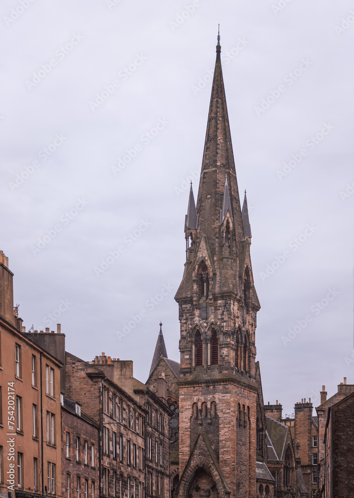 The impressive spire of Barclay Viewforth Church stands tall above the historic residential architecture of Edinburgh, under a blanket of soft grey clouds (Vertical photo)