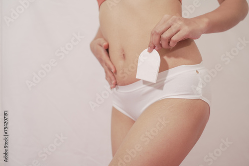 woman wearing underwear White holds a menstrual sanitary napkin. white background