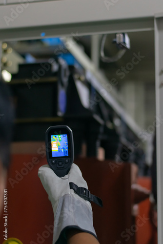 Professional Electrician use thermal infrared camera or thermometer scanning electrical system for preventive maintenance,Industrial thermography,Thermal image of power electric. photo