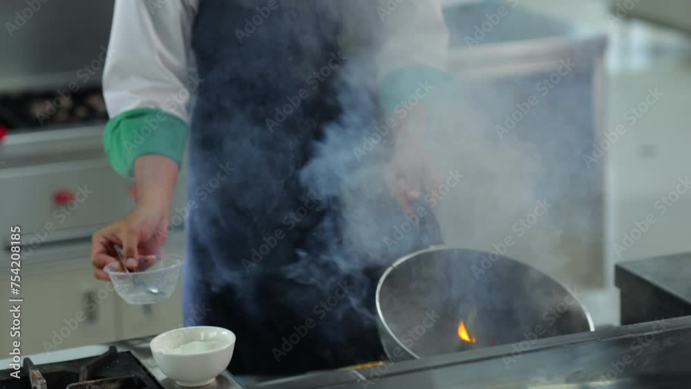 Thai Asian man professional chef cooking meal with fire at kitchen restaurant. culinary classroom. cooking school. cooking lessons in a cooking school. Thai Asian man professional chef cooking meal with fire at kitchen restaurant. culinary classroom. cooking school. cooking lessons in a cooking school.