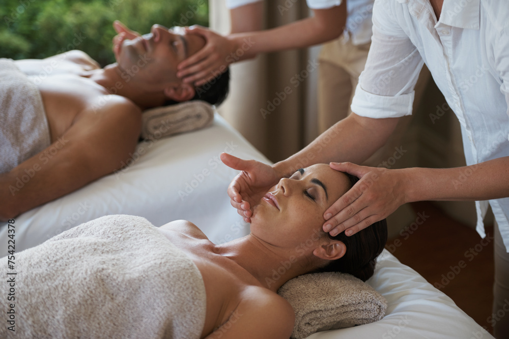 Holiday, head massage and couple relax in spa for care of body with rest on table of retreat for honeymoon. Hotel, man and woman together in resort for health, wellness and luxury for skincare