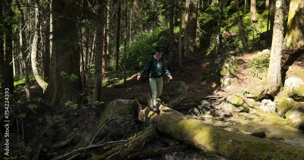 Hiking woman walk with a hiking backpack in spring green forest Hiking woman walk with a hiking backpack in spring green forest