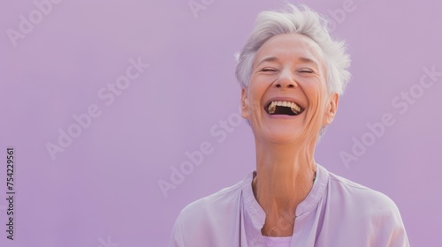 An elderly woman's laughter lights up the lavender backdrop, showcasing a carefree spirit and love for life in her relaxed attire.