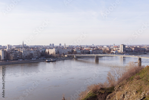 Cityscape of Novi Sad, bridge over Danube river. Panoramic view. Downtown at riverside. Cloudy spring day at noon. Serbia. Europe. 