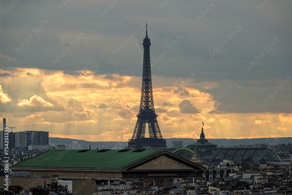 Vue panoramique sur le ciel de Paris en hauteur et la tour Eiffel avec rayons du soleil traversant les nuages	