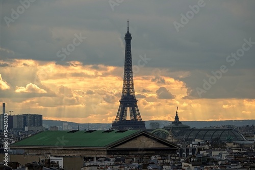 Vue panoramique sur le ciel de Paris en hauteur et la tour Eiffel avec rayons du soleil traversant les nuages 