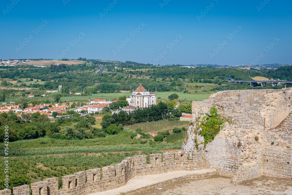Castle walls in Obidos town, Oeste region, Leiria District of Portugal, view with Sanctuary of the Lord of the Stone on background