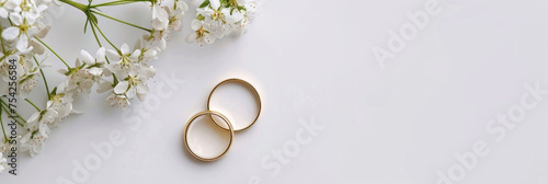 two golden wedding rings and flowers  on white background. banner