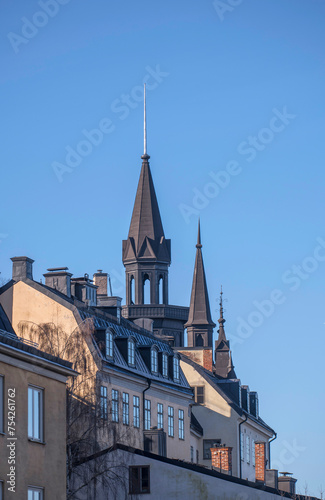 Facades tin roof with dorms, chimneys and towers in the district Mariaberget, a sunny winter day in Stockholm