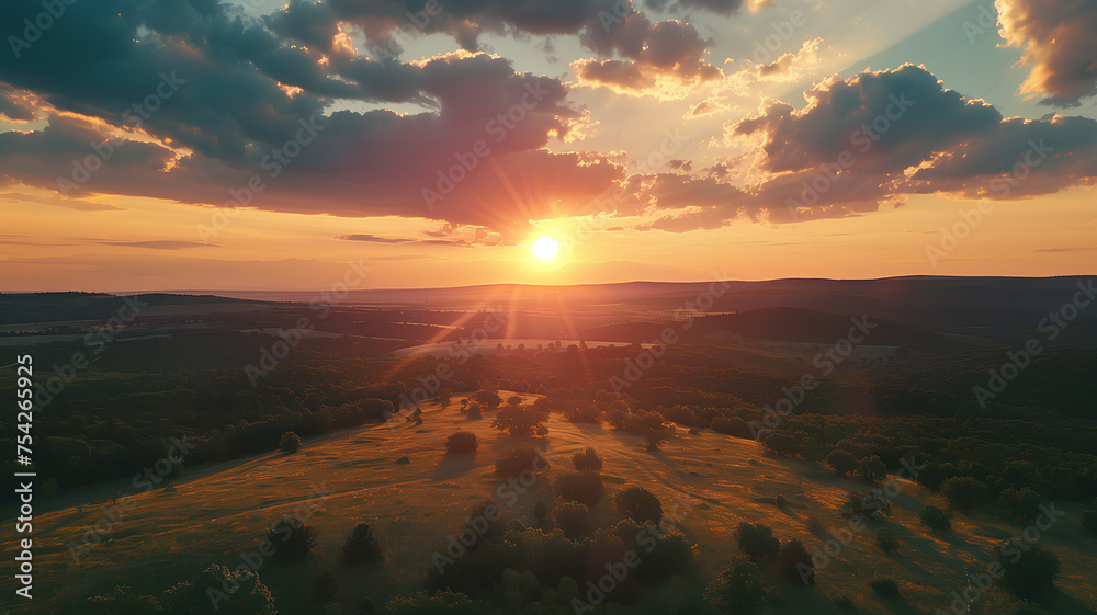Sunset Over Rolling Hills and Forest
. The sun sets casting a warm glow over undulating hills and a dense forest, with dramatic clouds in the sky.
