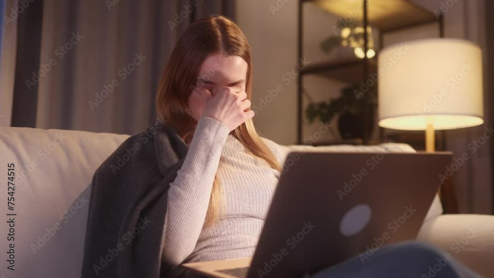 Unhappy young blond woman student or freelancer with closing eyes suffering headache painful feelings chronic migraine high or low pressure after hard laptop computer work at home late Unhappy young blond woman student or freelancer with closing eyes suffering headache painful feelings chronic migraine high or low pressure after hard laptop computer work at home late