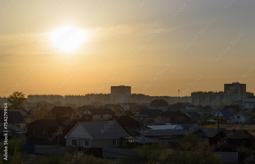 Evening landscape with village houses and multi-storey houses on the horizon sunset
