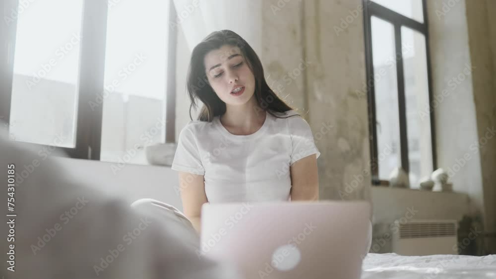 Portrait of beautiful young woman having video call conference meeting by laptop computer laying on bed at home Smiling female talking on personal conversation indoors Distance relationship concept Portrait of beautiful young woman having video call conference meeting by laptop computer laying on bed at home Smiling female talking on personal conversation indoors Distance relationship concept