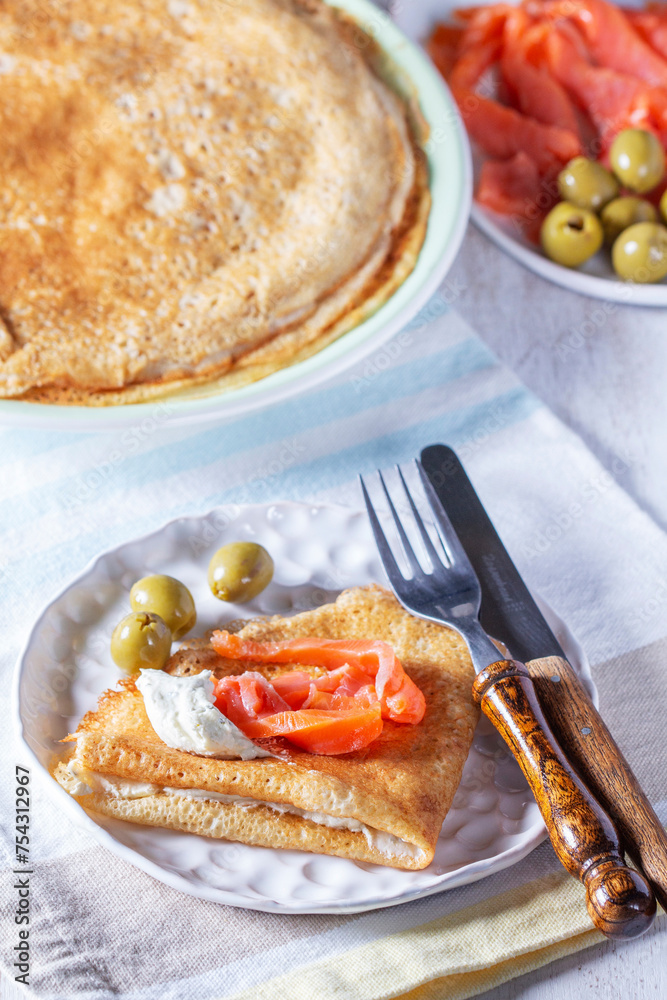 Pancakes with gravlax, cottage cheese and olives. A traditional dish for Maslenitsa or Carnival.