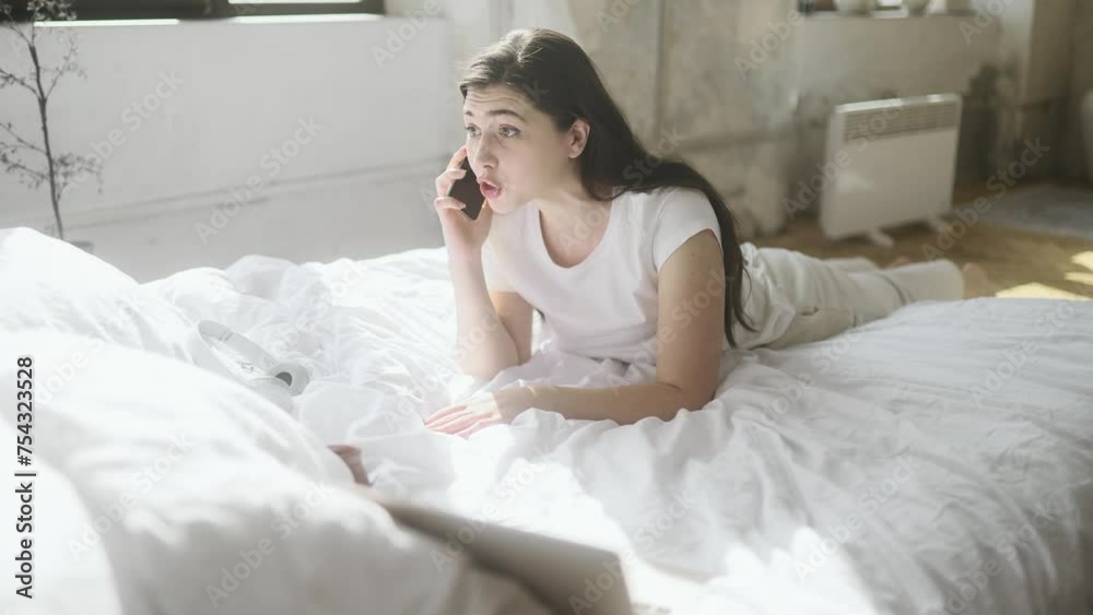 Irritated arguing young woman yelling at mobile phone while laying on bed at home Angry nervous female talk on smartphone expressing negative emotion Bad conflict working or personal conversation Irritated arguing young woman yelling at mobile phone while laying on bed at home Angry nervous female talk on smartphone expressing negative emotion Bad conflict working or personal conversation