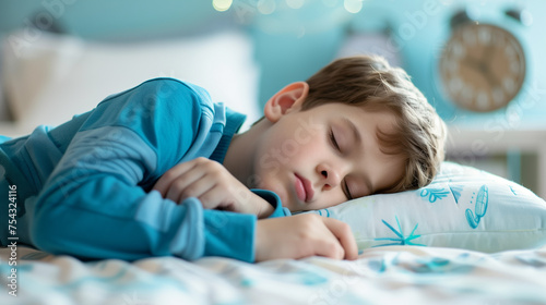 A first grade boy sleeps in his room in front of an alarm clock that will soon wake him up before school.