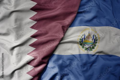 big waving national colorful flag of el salvador and national flag of qatar.