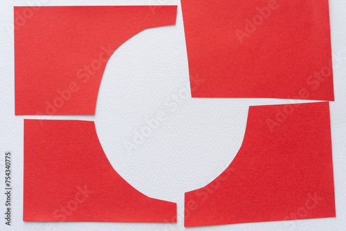 red paper quarters joined on a textured paper surface to form an open circle frame