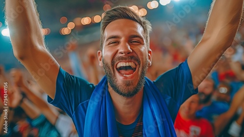 A delighted football fan, yelling and waving his arms in the air to indicate his affection for the game photo