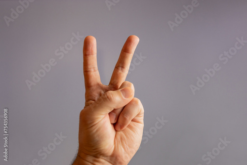 Showing victory with a finger gesture in the form of the letter 