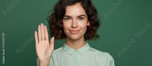 A young Caucasian woman is depicted in this drawing, holding her hand up in a greeting gesture, almost as if shielding her face. The woman is isolated on a green background.