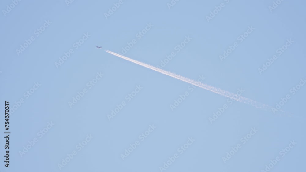 Airplane flying and leaving contrails behind on a clear blue sky. Airplane flying and leaving contrails behind on a clear blue sky.