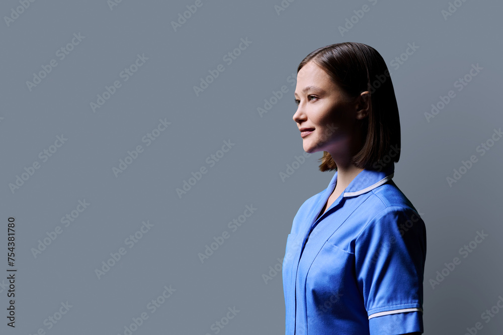 Portrait of young female nurse looking in profile on gray background Portrait of young female nurse looking in profile on gray background