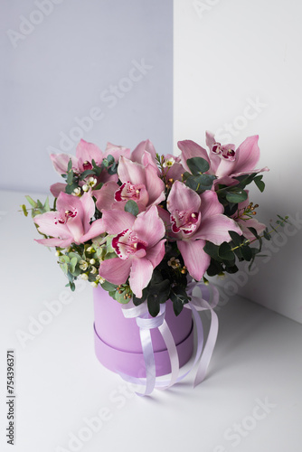 Flowers in a purple box. European bouquet of pink flowers and greenery. Orchids and eucalyptus. Flower shop. Delivery. Master Class. For background design  banner