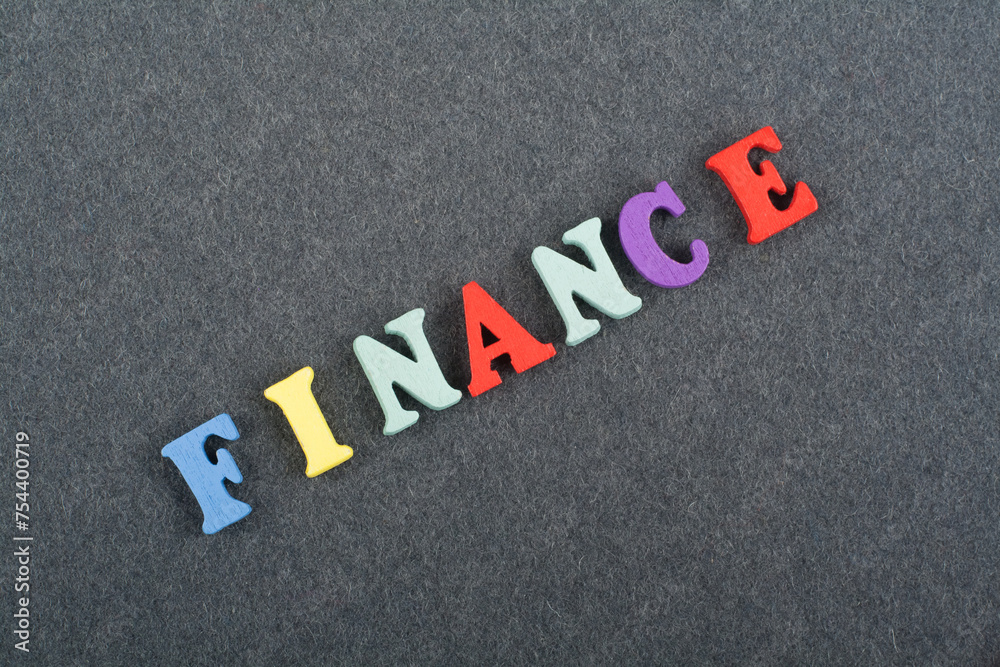 FINANCE word on black board background composed from colorful abc alphabet block wooden letters, copy space for ad text. Learning english concept. FINANCE word on black board background composed from colorful abc alphabet block wooden letters, copy space for ad text. Learning english concept.