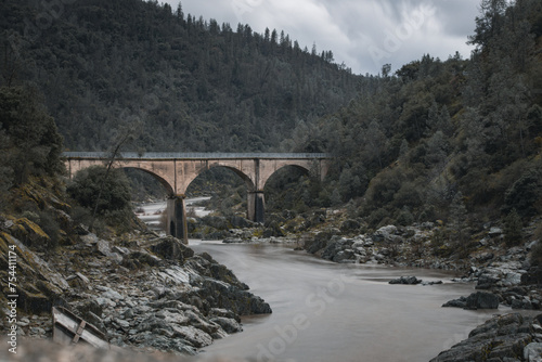 bridge over the river in the mountains with water moving rapid