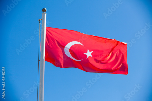 Turkish flag on a flagpole against the blue sky