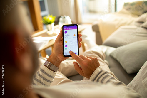 Man checking bank account on smartphone at home photo