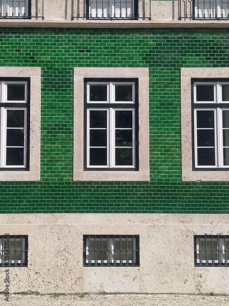 Urban Elegance: Zooming in on a Green Metro Tile Facade with Stone Window Frames - Vintage Charm in Modern Architecture