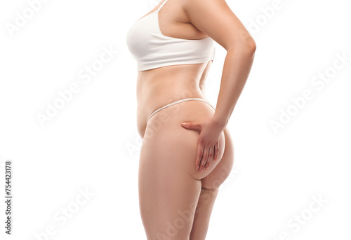 The girl stretches the skin on the leg and on the stomach  showing fat deposits. Treatment and getting rid of excess weight  the deposition of subcutaneous fat.
