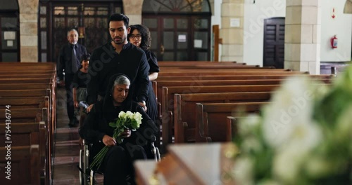 Grief, family and old woman in wheelchair at funeral together for memorial service at church for respect, support and comfort. Death, chapel and men and widow with memory, loss and spiritual farewell photo