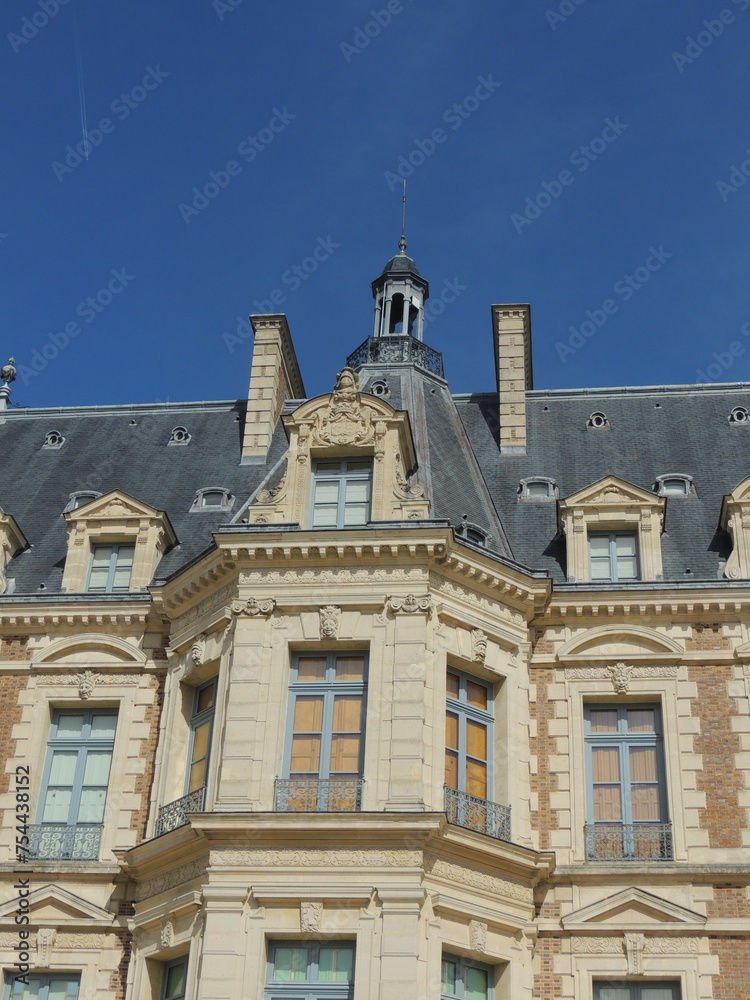 Timeless Elegance: Zoomed-In View of Chateau de Sceaux with Stone Walls, Slate Roof, and Grand Windows Against Clear Blue Sky - Capturing Architectural Beauty of French Heritage