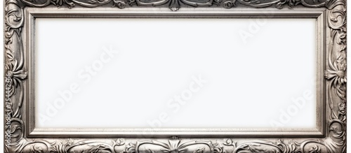 An ornate silver frame, suitable for paintings, mirrors, or photos, is displayed against a clean white background. The intricate details of the frame enhance its elegance and sophistication. photo