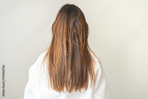 Damaged hair, frustrated asian young woman, girl in splitting ends, messy unbrushed dry hair and frizzy with long disheveled hair, health care of beauty. Portrait isolated on background, Back view.