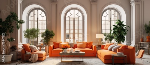 A classic living room is filled with elegant orange furniture, including a sofa with poufs, coffee tables, vases, and decor items. The room features archways, an arched window, and a door,