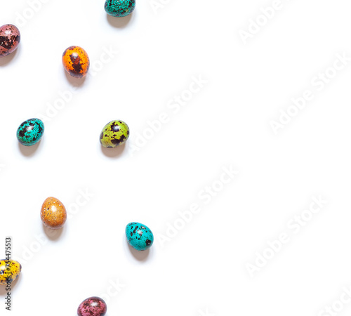 Colorful painted Easter quail eggs on the white background. Top view. Copy space
