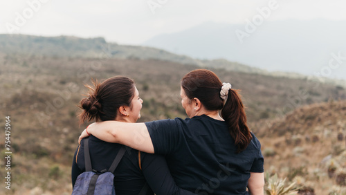 A heartfelt moment as a mother and daughter embrace, enjoying the serene Colombian paramo landscape