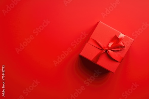 A striking red gift box with satin ribbon centered on a vibrant red backdrop.