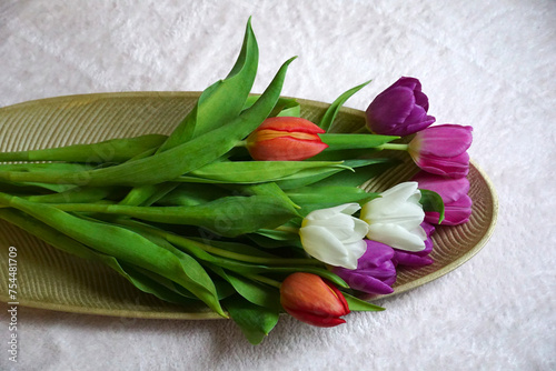 Fototapeta Naklejka Na Ścianę i Meble -  A bouquet of colorful tulips placed on a decorative surface