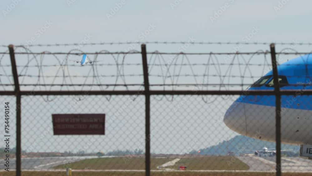 PHUKET, THAILAND - FEBRUARY 10, 2023: Boeing 787-8 Dreamliner, G-TUIE of TUI Airways taxiing to the runway at Phuket Airport. Airplane behind the fence of the airport, side view medium shot PHUKET, THAILAND - FEBRUARY 10, 2023: Boeing 787-8 Dreamliner, G-TUIE of TUI Airways taxiing to the runway at Phuket Airport. Airplane behind the fence of the airport, side view medium shot