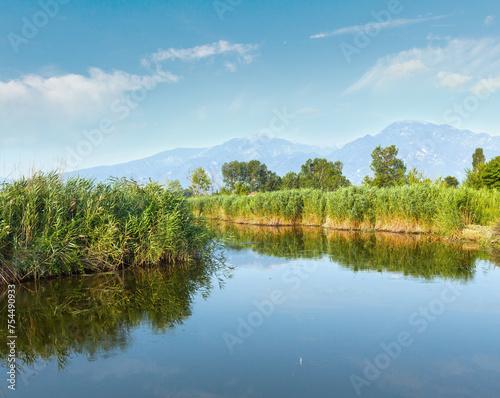 Summer morning misty mountain landscape with water surface in front  (Greece). © wildman