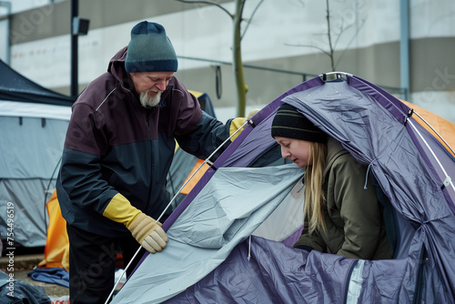 Volunteer assisting with tent setup © kossovskiy