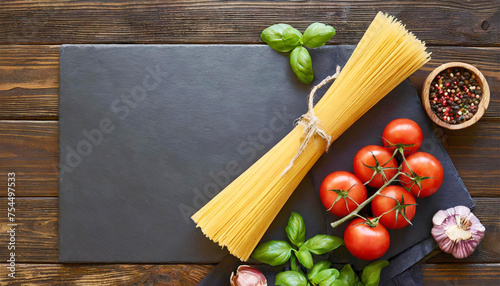 Uncooked raw Italian pasta, tomatoes, basil, cooking ingredients, with copy space