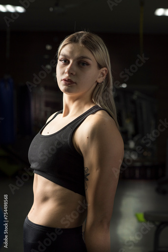 Portrait of a young beautiful blonde sportswoman in the gym.